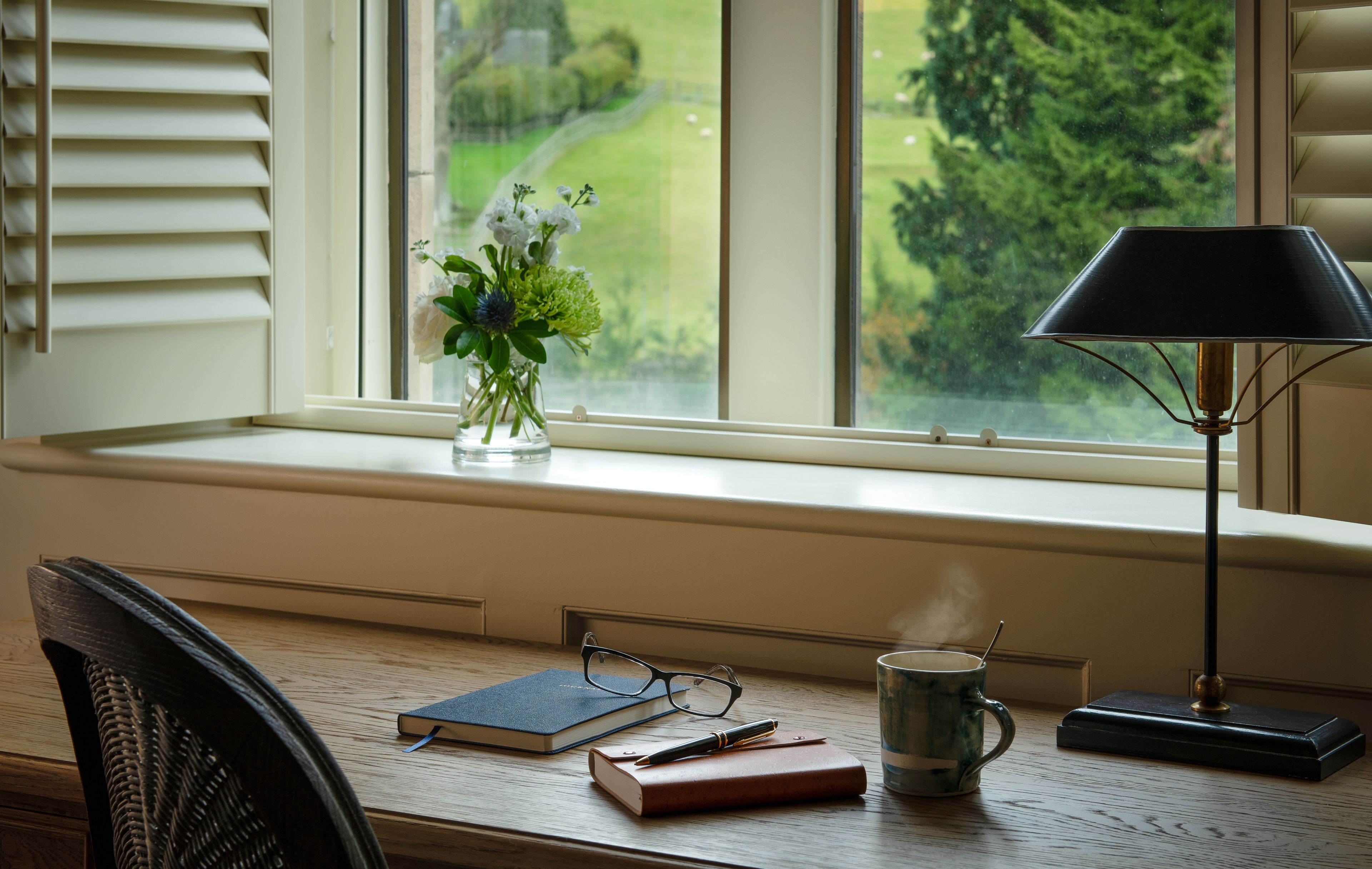 A room desk area with a view of the gardens