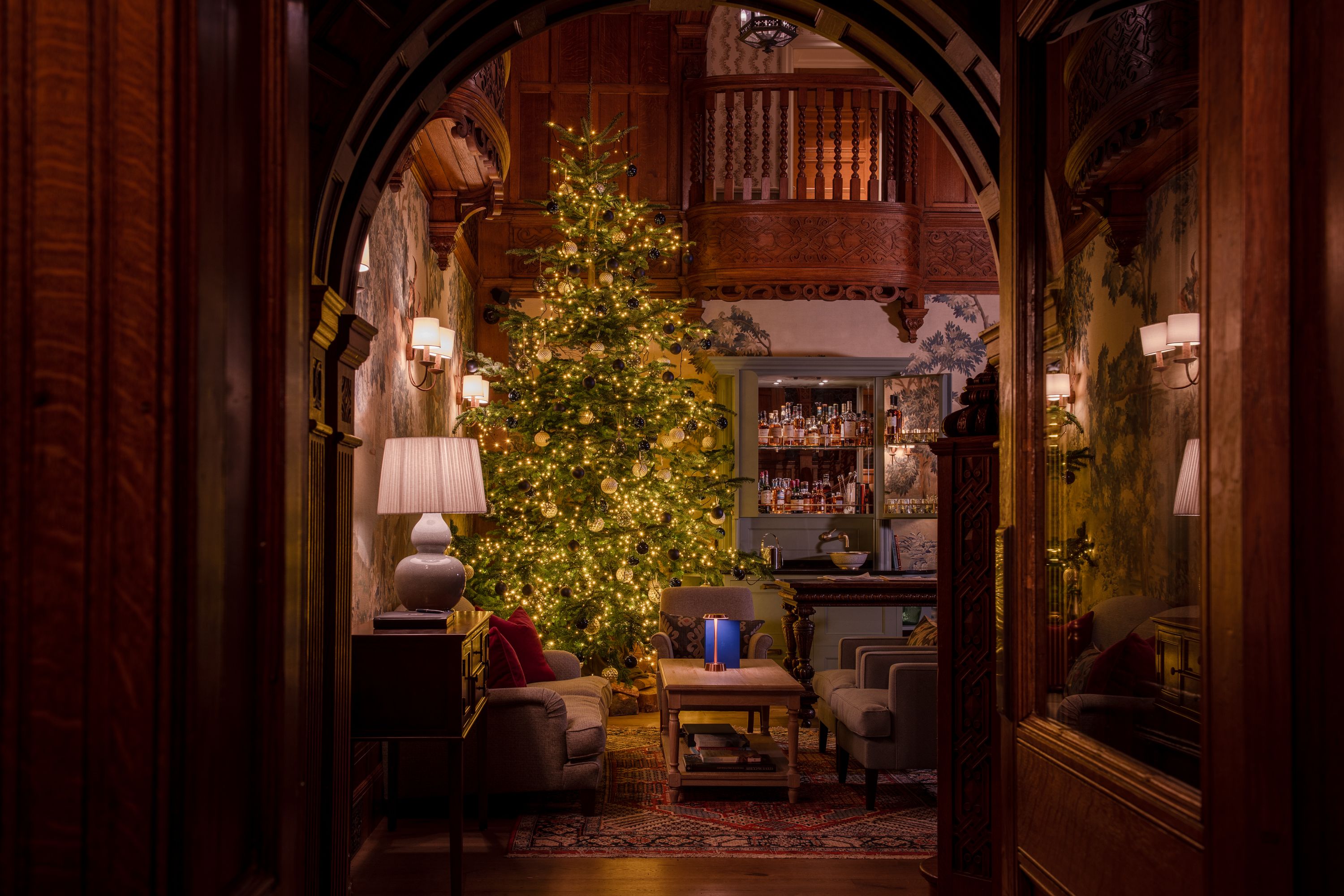 A large, well-lit Christmas tree in the lounge area