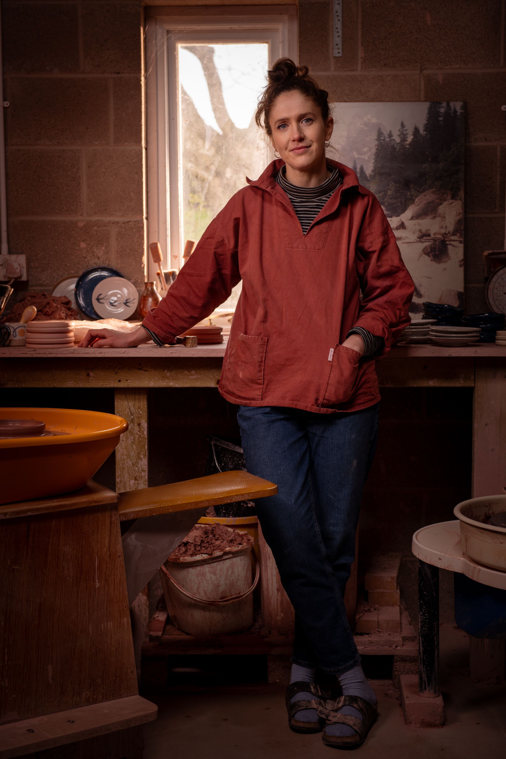 A potter standing in her workspace