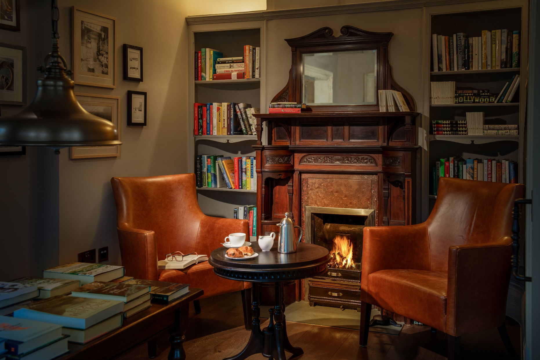 cozy library with fireplace, armchairs, and book