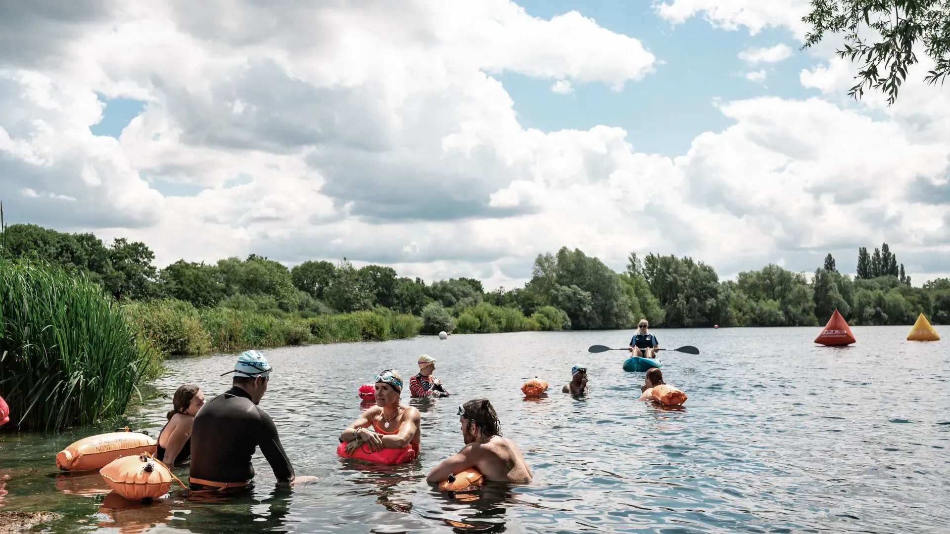 people resting on floating devices in a lake