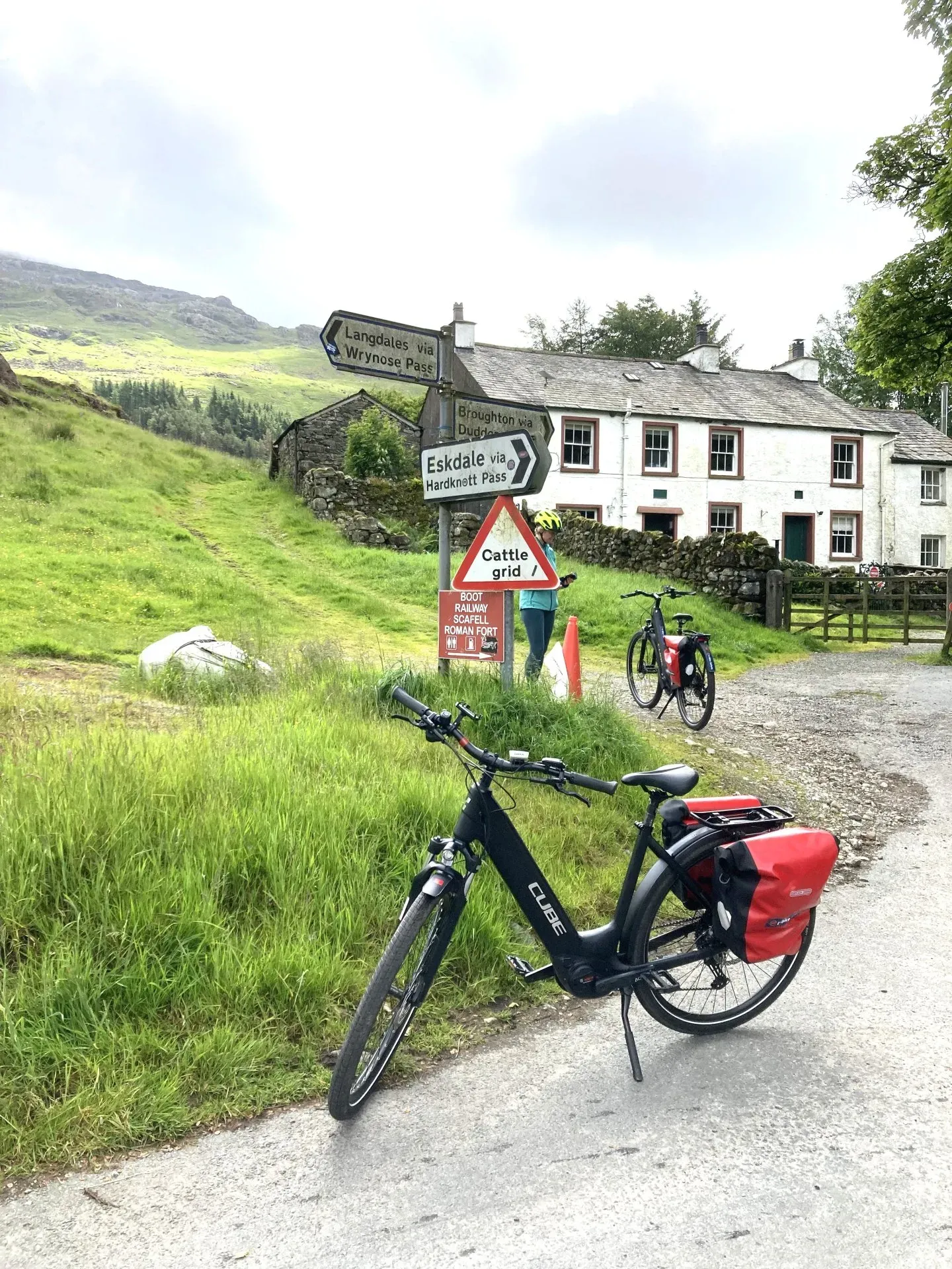 bikes in front of a sign and house in the countryside