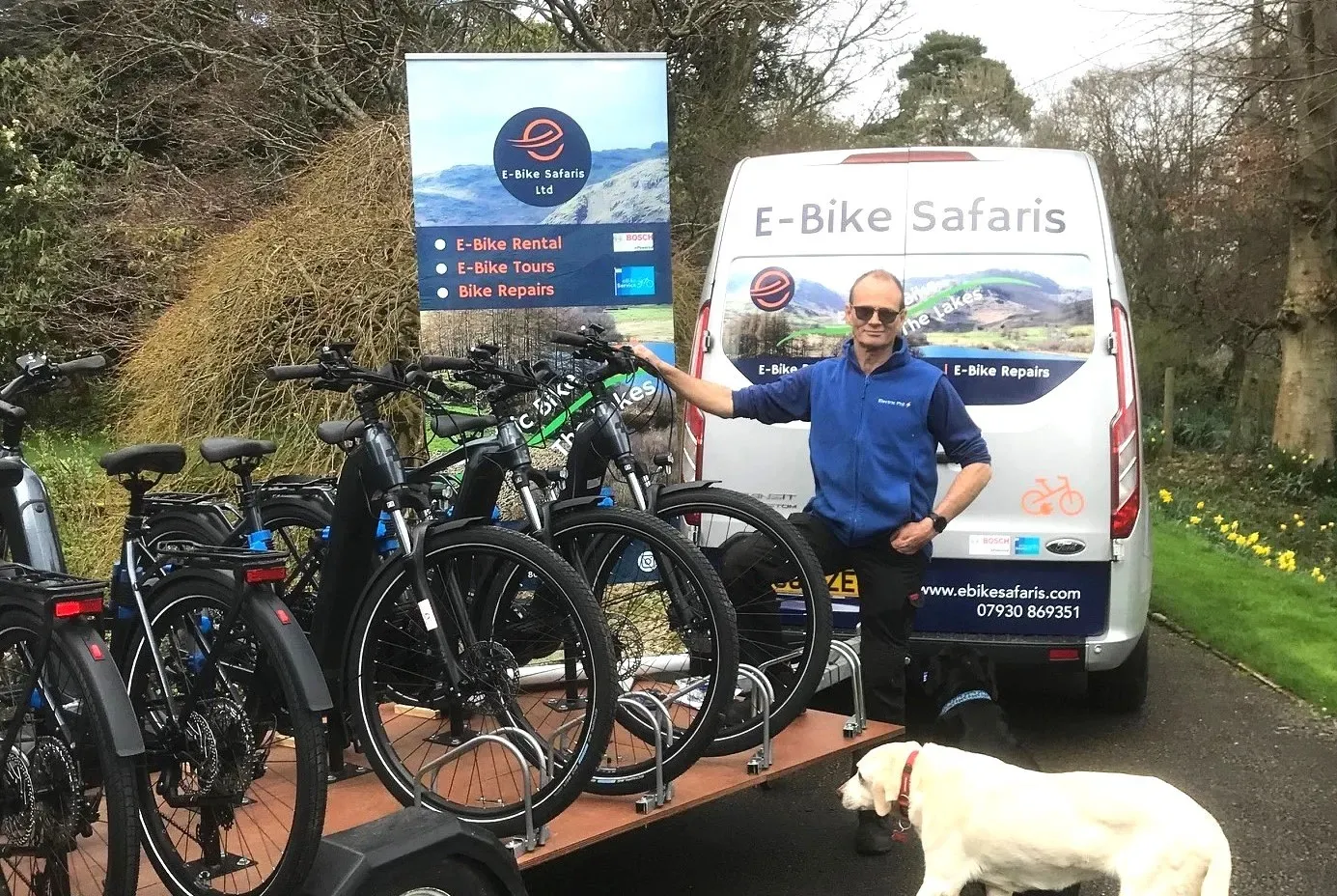 man standing beside ebikes and a van with an E bike safari label