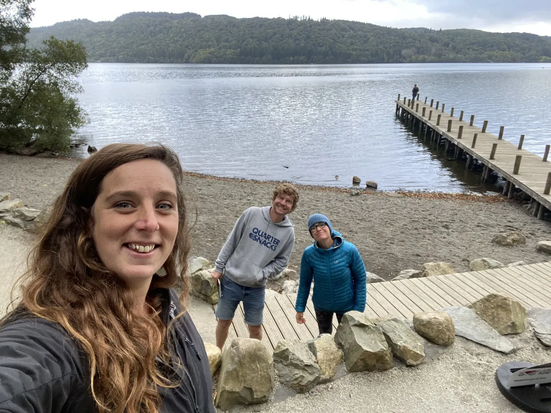 people smiling beside a long dock overlooking the lake