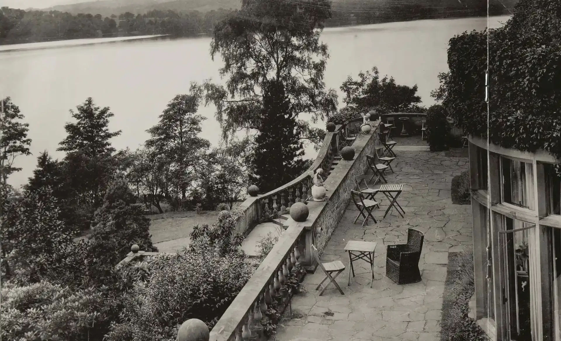 black and white photo of a Victorian-era terrace overlooking a lake