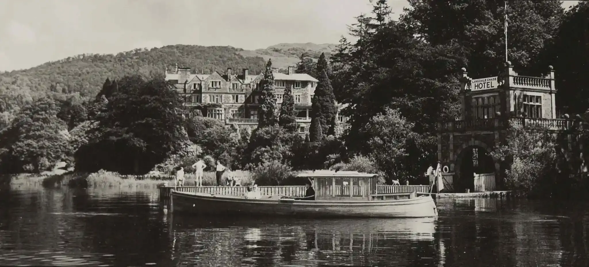 black and white photo of a Victorian-era hotel on a lake