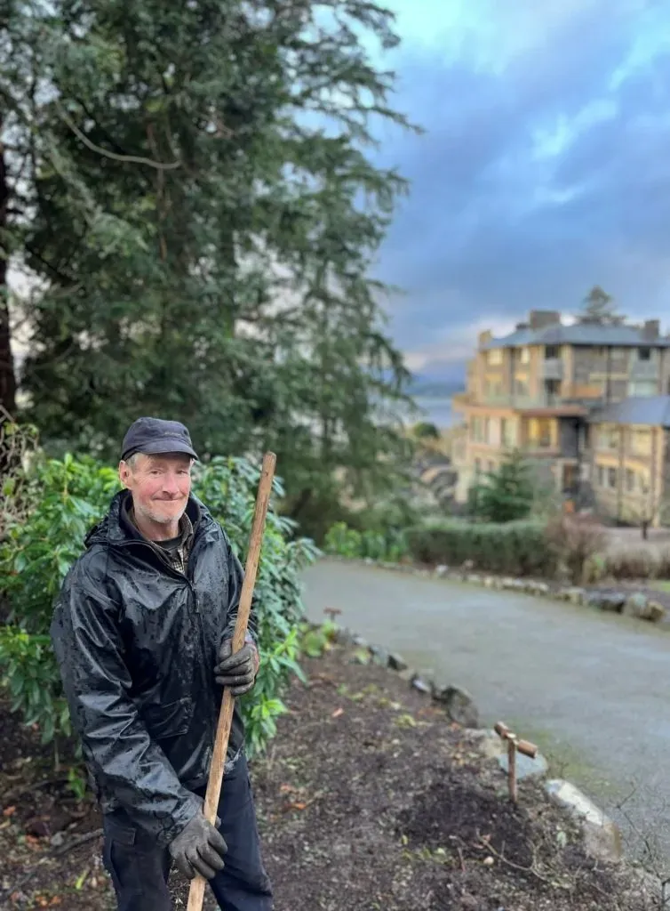 A man stood outside the building in the gardens.